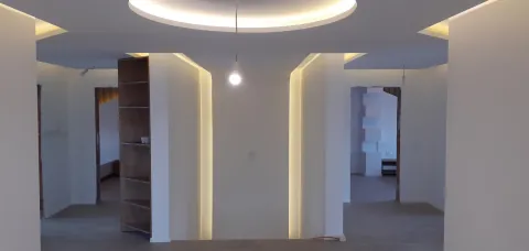 Wohnraum mit abgehängter Decke und indirekter Beleuchtung