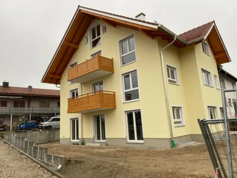 Fertige Putzfassade eines Wohnhauses mit Holzbalkonen