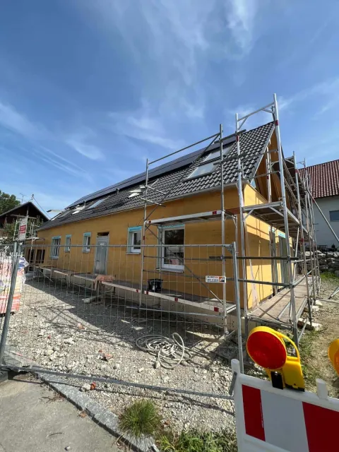 Hausfassade mit Holzfaser-Dämmplatten während der Sanierung