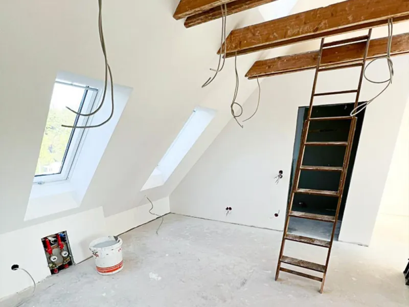 Ausgebautes Dachgeschoss mit hellen Trockenbauwänden und Dachschrägen
