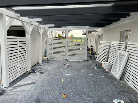 Weiß gestrichener Carport mit abgedecktem Boden während der Arbeiten